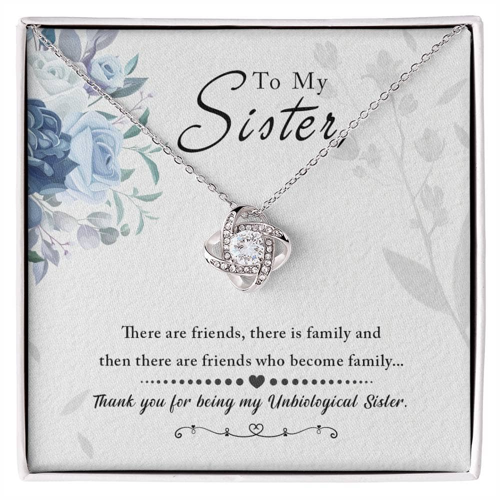 A close-up of a diamond necklace with interlocking hearts and a love knot pendant, symbolizing the bond between unbiological sisters.