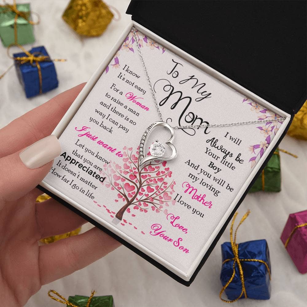 A hand holding the Enduring Love Personalized Mother Necklace in a box, symbolizing unending love and appreciation.