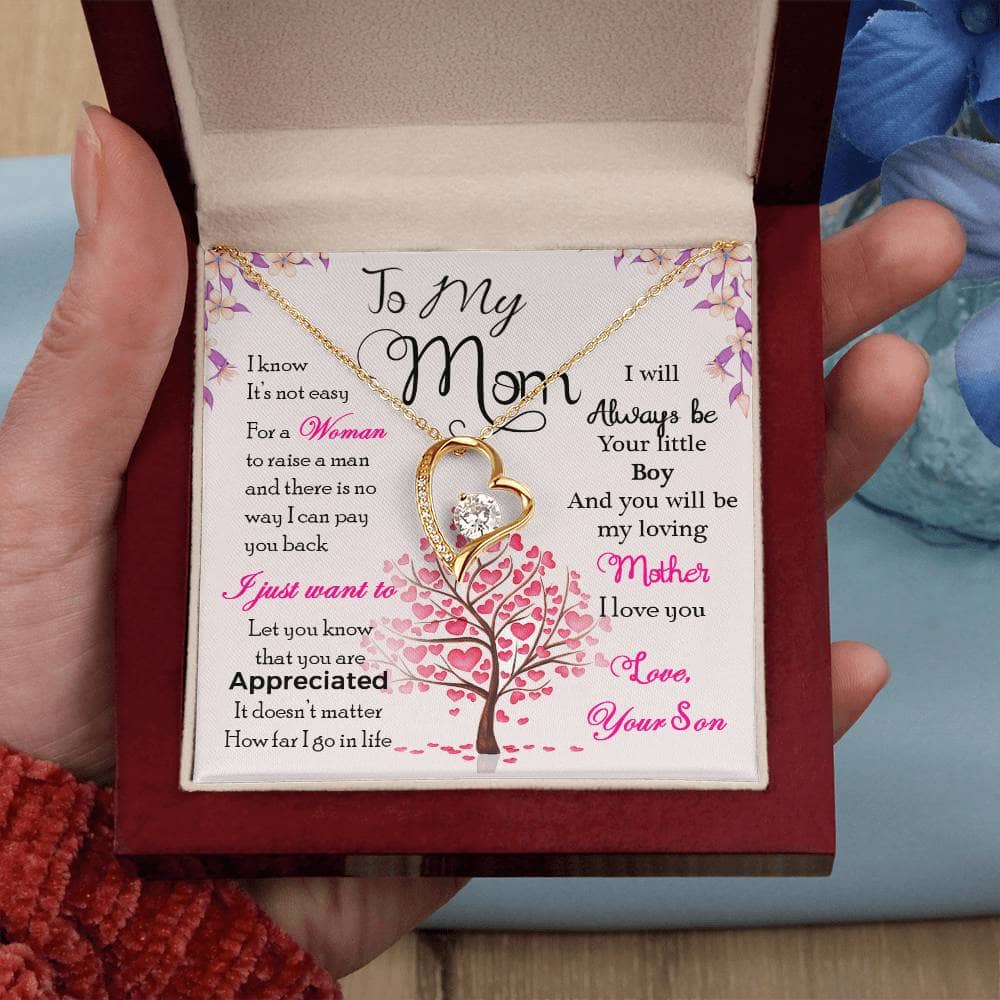 A hand holding a box with a necklace from the Enduring Love Personalized Mother Necklace Collection.