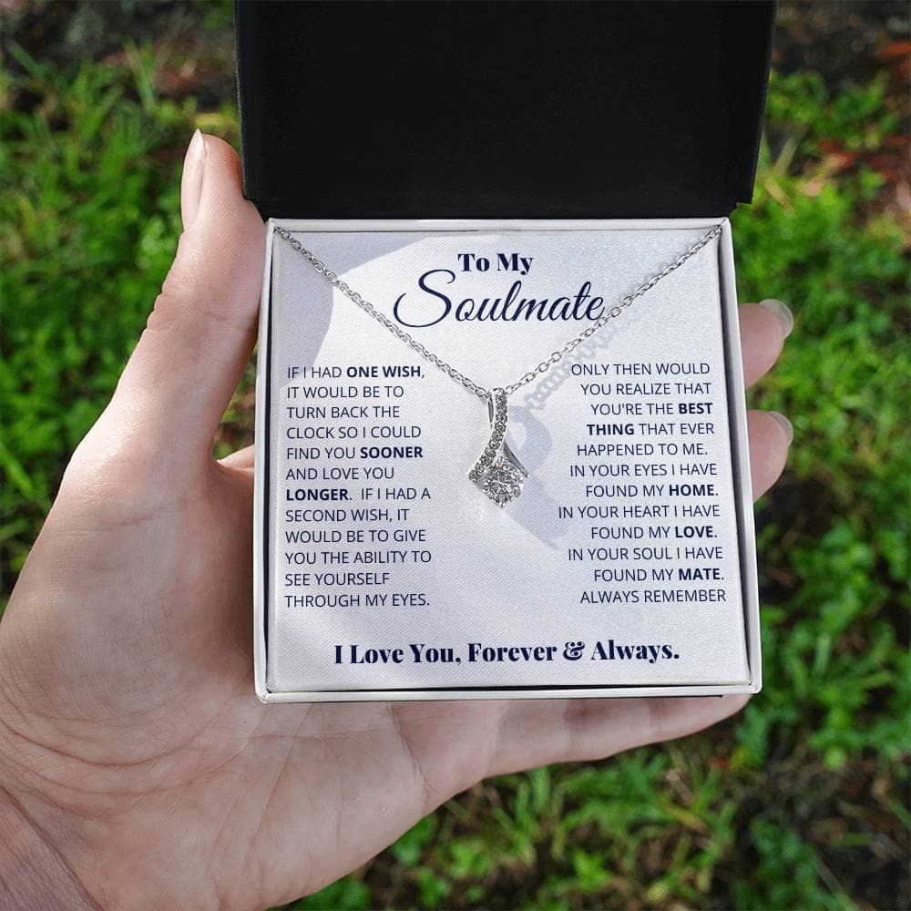 Alt text: "Hand holding Alluring Beauty Necklace in box, symbol of timeless love and commitment, 14k white or 18k gold finish, adjustable chain, LED lighted gift box."