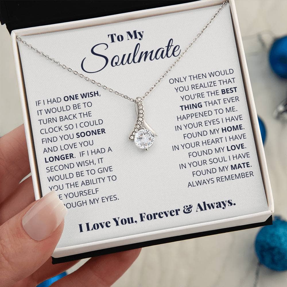 Alt text: "Hand holding Alluring Beauty Necklace, a symbol of timeless love and commitment, with a small box and message."