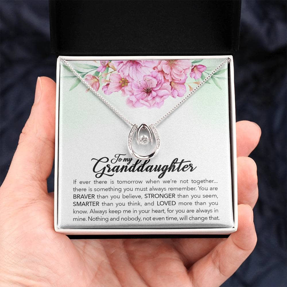 A hand holding the Always in Heart - Personalized Granddaughter Necklace in a box with LED lighting.