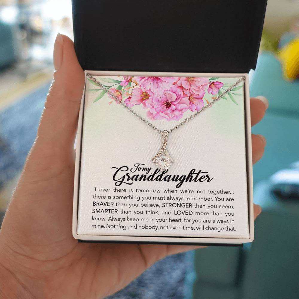 Alt text: "A hand holding the 'Always in Your Heart' Personalized Granddaughter Necklace in a box"