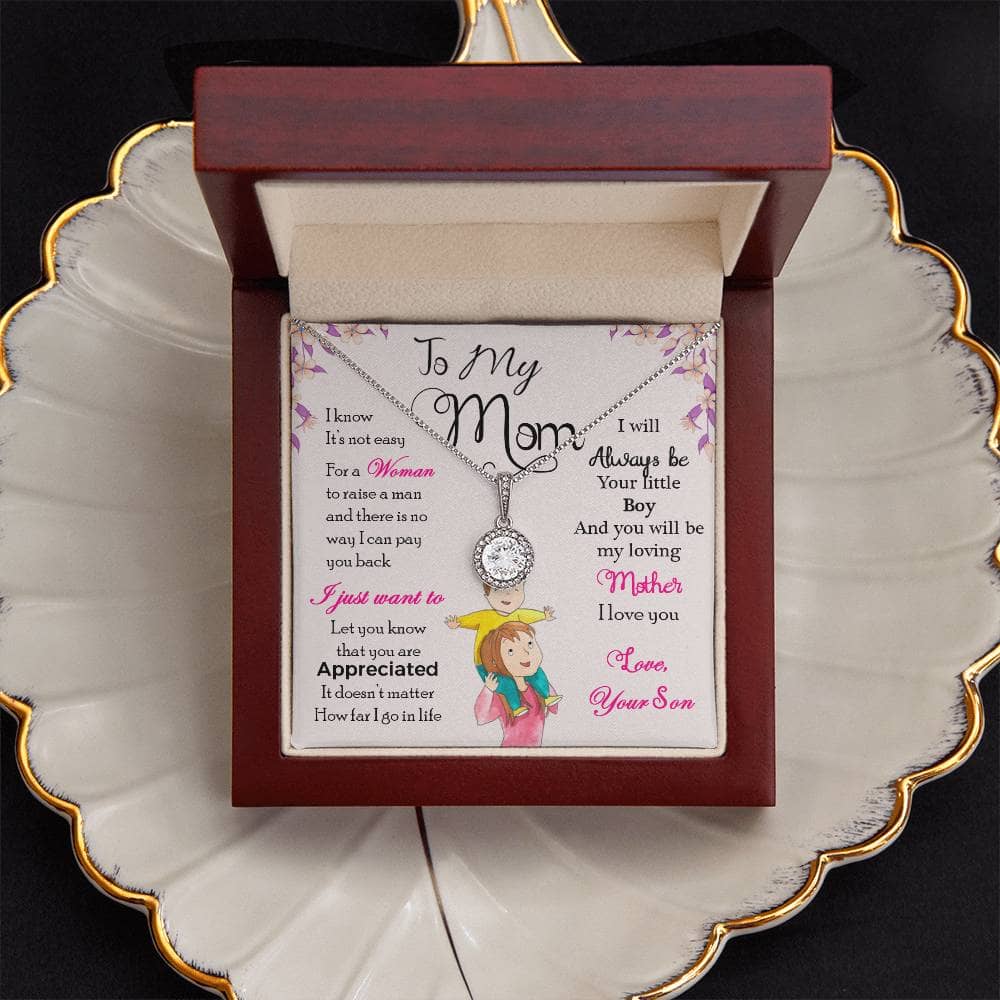 Alt text: "Personalized Mother's Day Necklace in LED-lit mahogany-styled box on a plate"