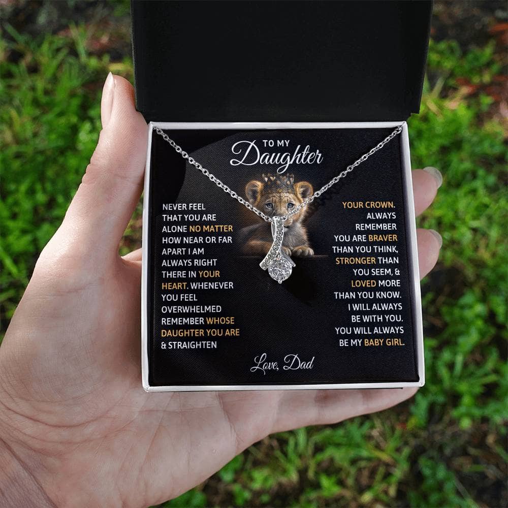 Alt text: "A hand holding a personalized daughter necklace in a box, symbolizing the cherished bond between parents and daughters."