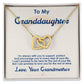 A gold necklace in a box, featuring a heart-shaped pendant symbolizing the bond between a grandmother and granddaughter. Adjustable chain options available.