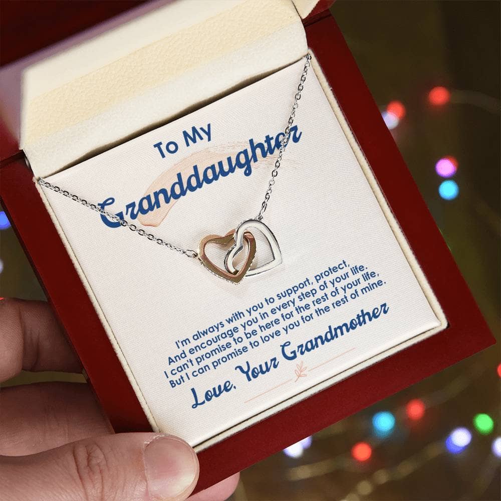 A hand holding the Cherished Bond Personalized Granddaughter Necklace in a box.