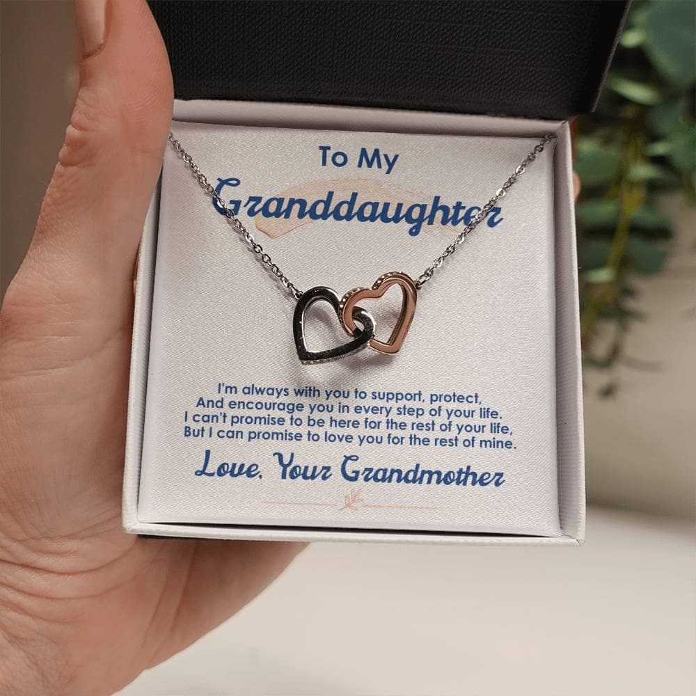 A hand holding a necklace with two hearts, symbolizing the cherished bond between a grandmother and her granddaughter.