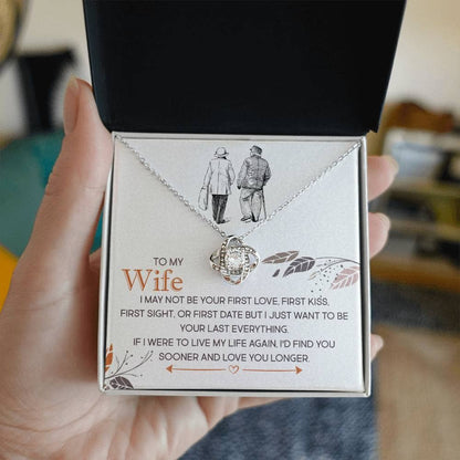 Alt text: "A hand holding the Cherished Personalized Wife Necklace Knot in a box, symbolizing everlasting love and elegance."