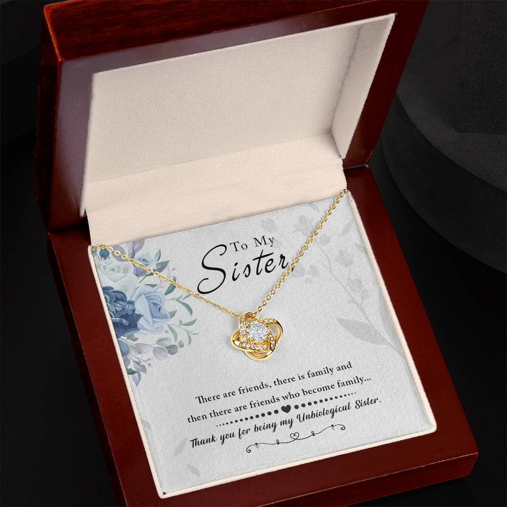 A close-up of a gold necklace with a diamond pendant, elegantly packaged in a mahogany-style box with LED lighting. Perfect for unbiological sisters, this Custom Love Knot Necklace celebrates the bond between sisters with exquisite craftsmanship and premium cubic zirconia.