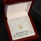 A gold necklace with a love knot pendant in a box, symbolizing the enduring connection between unbiological sisters.