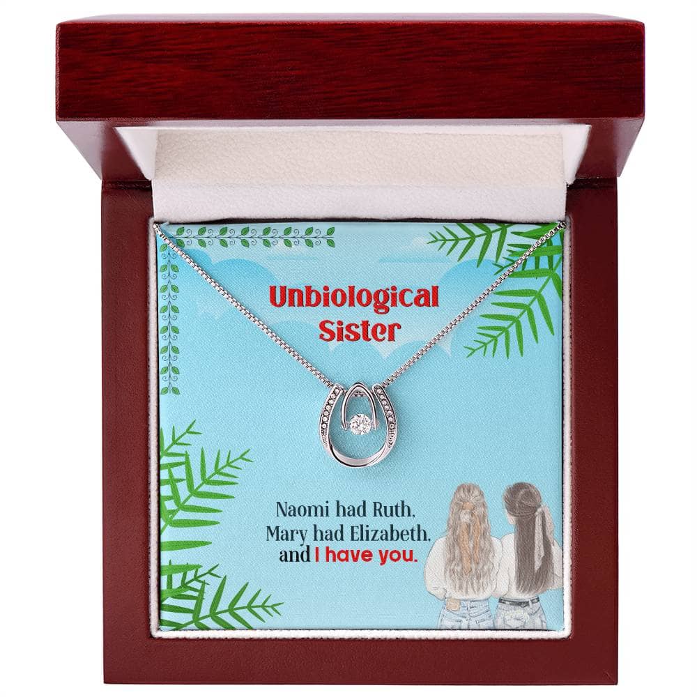 Alt text: "Custom Unbiological Sisters Necklace in a mahogany-style box with LED lighting, featuring interlocking hearts pendant and adjustable chain."