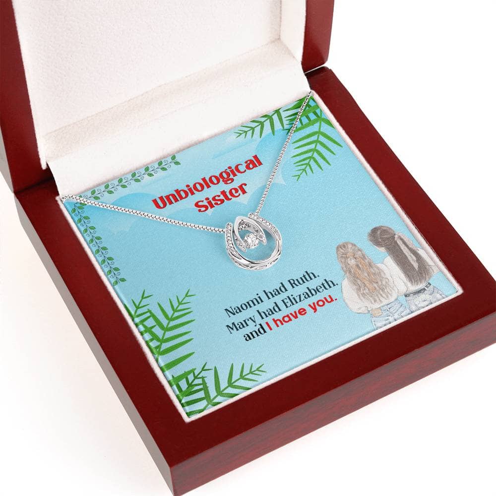 Alt text: "Custom Unbiological Sisters Necklace in a box, featuring interlocking heart pendant and adjustable chain. Symbolizes sisterly love and shared experiences. Luxe 14k white gold or elegant 18k gold finish. Enhance the gifting experience with a sophisticated mahogany-style box with LED lighting. A timeless tribute to sisterhood."