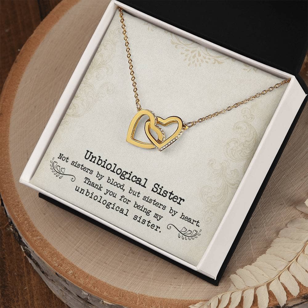 A gold heart necklace in a box, symbolizing eternal sisterhood. Personalized Unbiological Sisters Necklace with luminescent cubic zirconia.