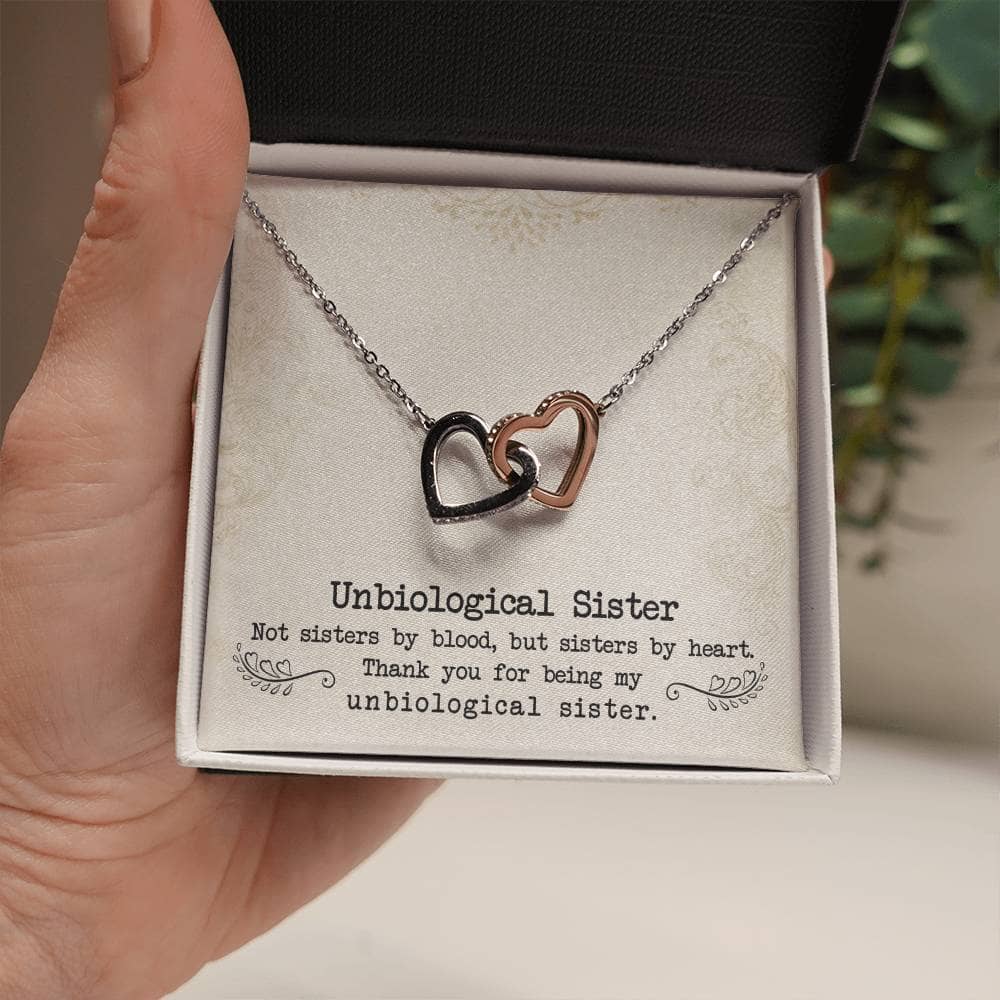 Alt text: "A hand holding a heart pendant necklace, symbolizing the unbreakable bond of unbiological sisters. Customizable design options available. Perfect gift for any occasion. Made with high-quality materials. From Bespoke Necklace."