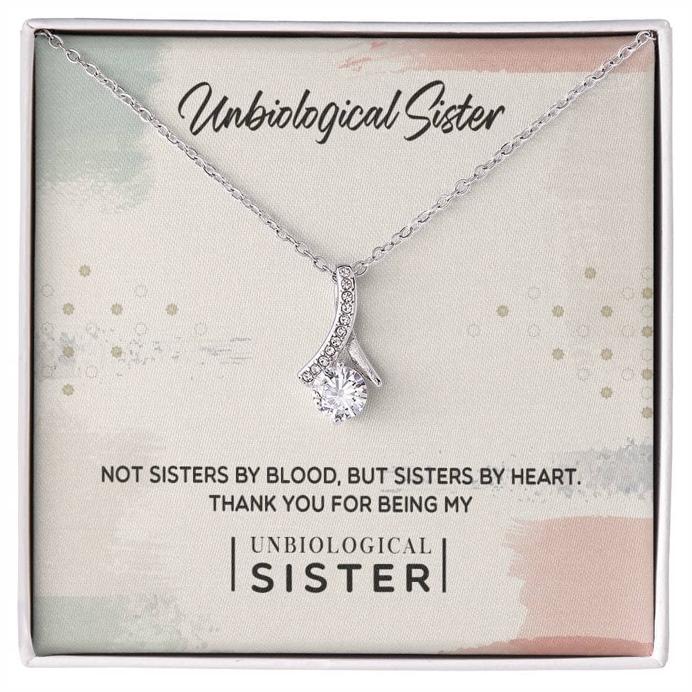 Customizable Unbiological Sisters Love Knot Necklace in a box, featuring a radiant cubic zirconia cushion-cut on a heart or knot pendant, available in 14k white gold or 18k gold finish.