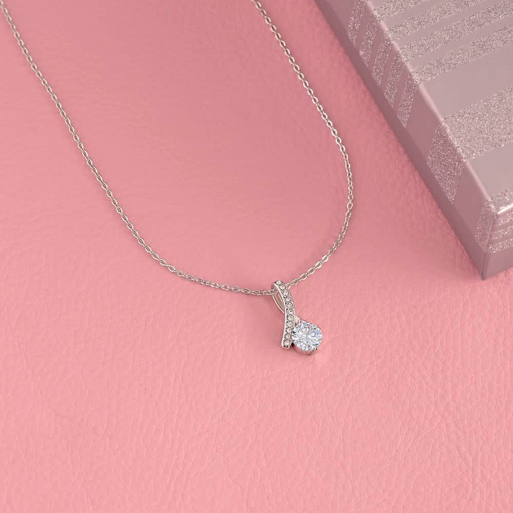 Alt text: "Customizable Unbiological Sisters Love Knot Necklace with diamond pendant on silver chain"