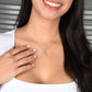 A woman wearing a Customizable Unbiological Sisters Love Knot Necklace, featuring a radiant cubic zirconia cushion-cut pendant in 14k white gold or 18k gold finish.