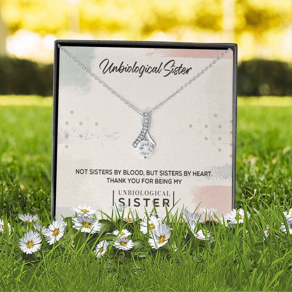 A necklace in a box with flowers, symbolizing the bond of unbiological sisters.