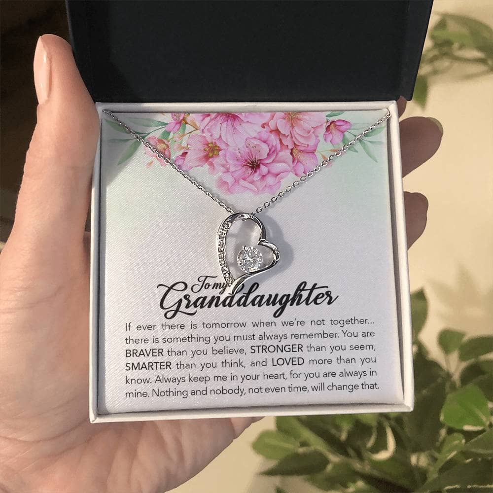 Alt text: A hand holding a personalized granddaughter necklace in a luxurious box with LED lighting