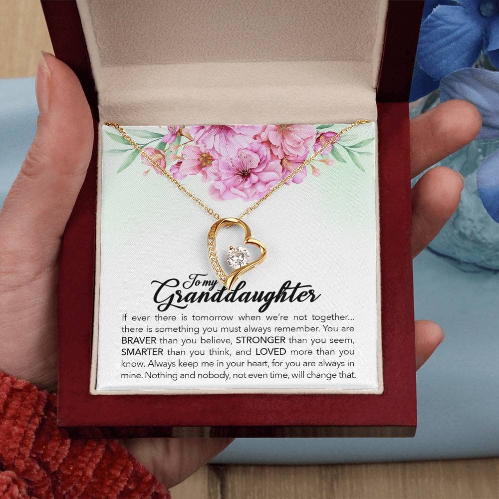 Alt text: "Hand holding a heart-shaped pendant necklace in a luxurious box, symbolizing the bond between grandparents and granddaughters."