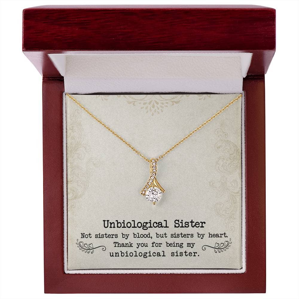 Alt text: "Gold necklace with diamond pendant in box, symbolizing unshakeable bond between unbiological sisters."