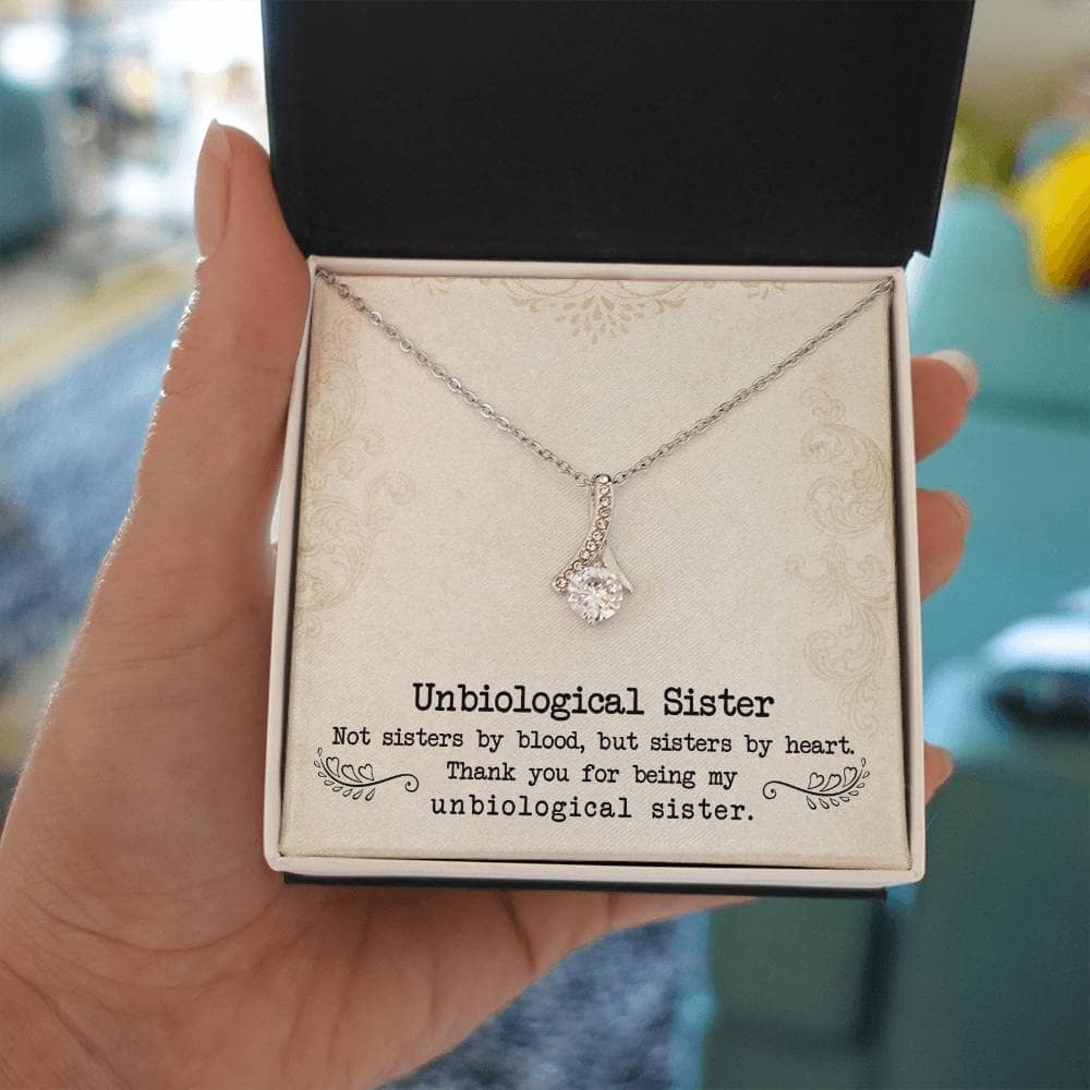 Alt text: "Customized Unbiological Sisters Necklace - A hand holding a necklace in a box, symbolizing the enduring bond between sisters. Shimmering 14k white gold or 18k gold finish with a cushion-cut cubic zirconia at the heart. Timeless accessory for casual and formal wear."