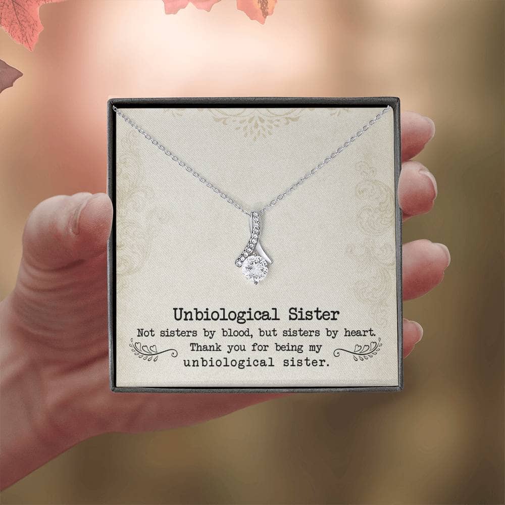 A hand holding a Personalized Unbiological Sisters Necklace, a shimmering testament to the enduring bond between sisters.