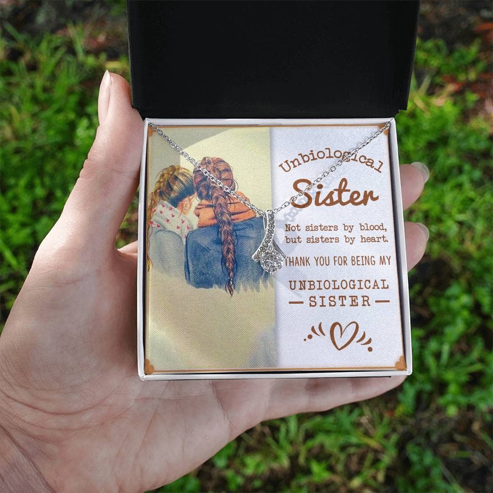 A hand holding a box with a picture of a woman and a child, showcasing the Customized Unbiological Sisters Alluring Charm Necklace.