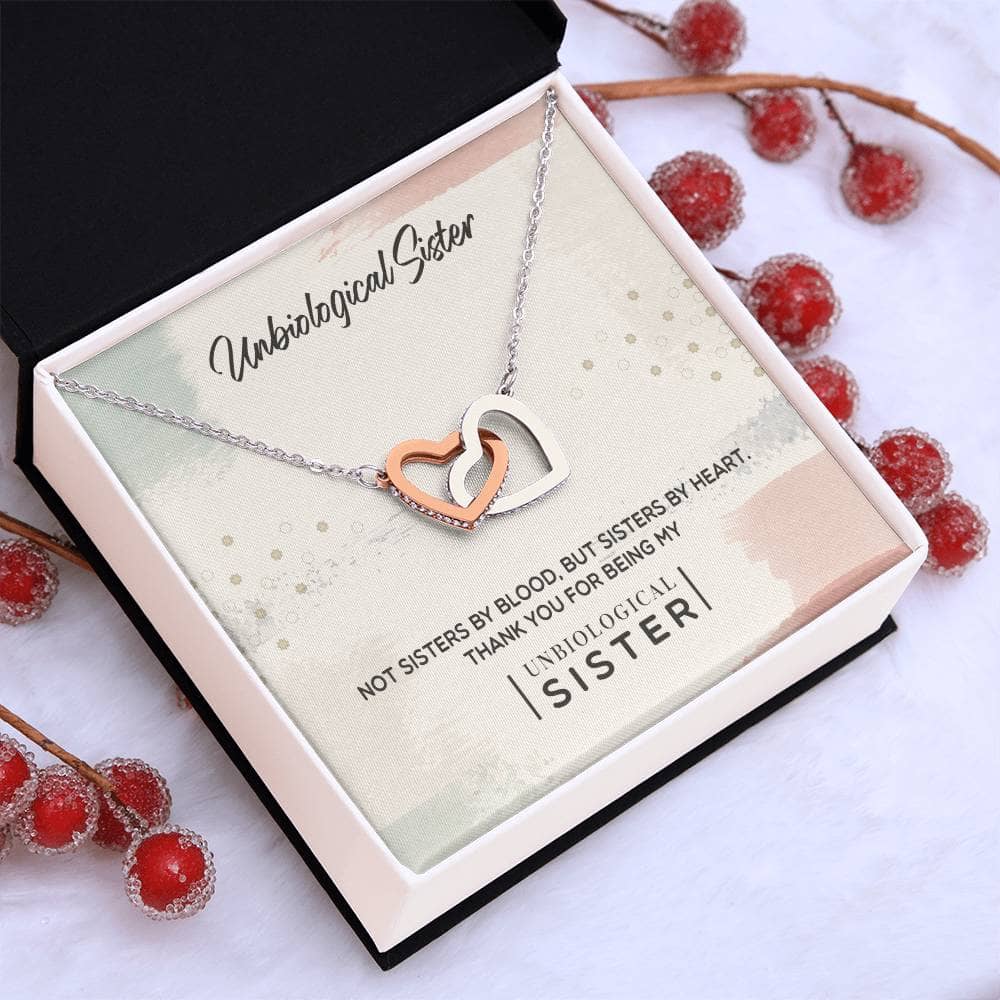 Alt text: "Customized Unbiological Sisters Necklace in a box, featuring interlocking hearts or love knot pendant designs, crafted with 14k white gold or 18k gold finish, adorned with cubic zirconia."