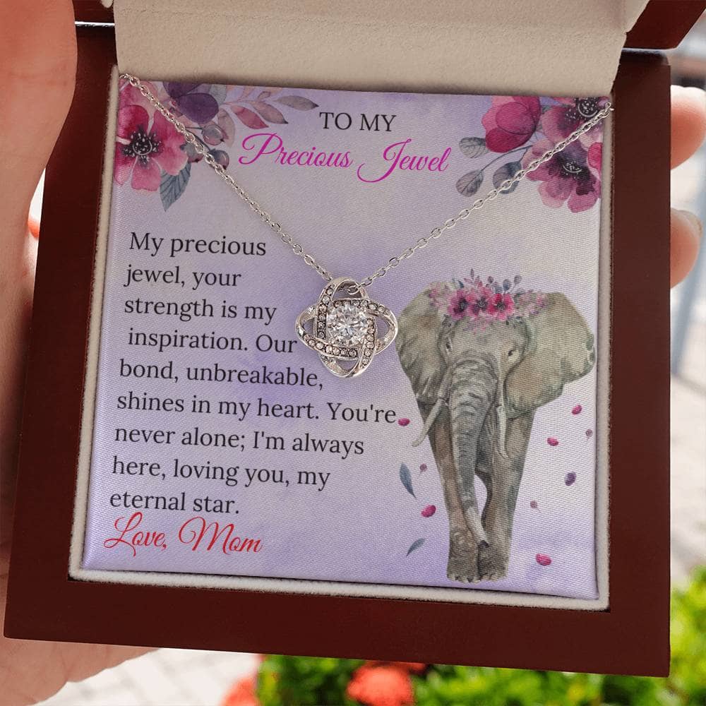 Alt text: "A hand holding an elegant personalized daughter necklace in a box, symbolizing an everlasting bond of love. Adorned with premium cubic zirconia, this necklace is a cherished keepsake. Perfect for birthdays, graduations, or expressing affection. Luxurious packaging included."
