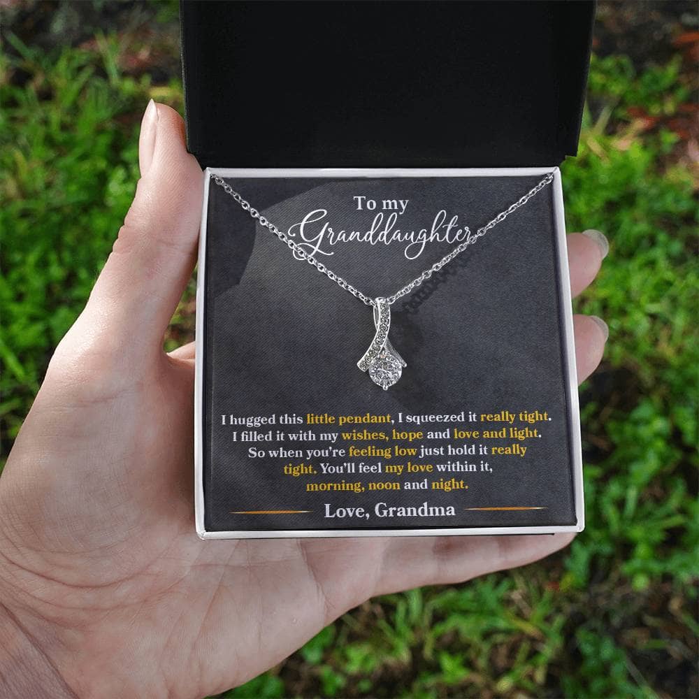 Alt text: "A hand holding an Elegant Personalized Granddaughter Necklace with Heart Pendant in a box"