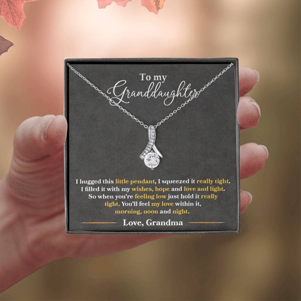 A hand holding an Elegant Personalized Granddaughter Necklace with Heart Pendant, symbolizing deep-seated love and cherished bonds.