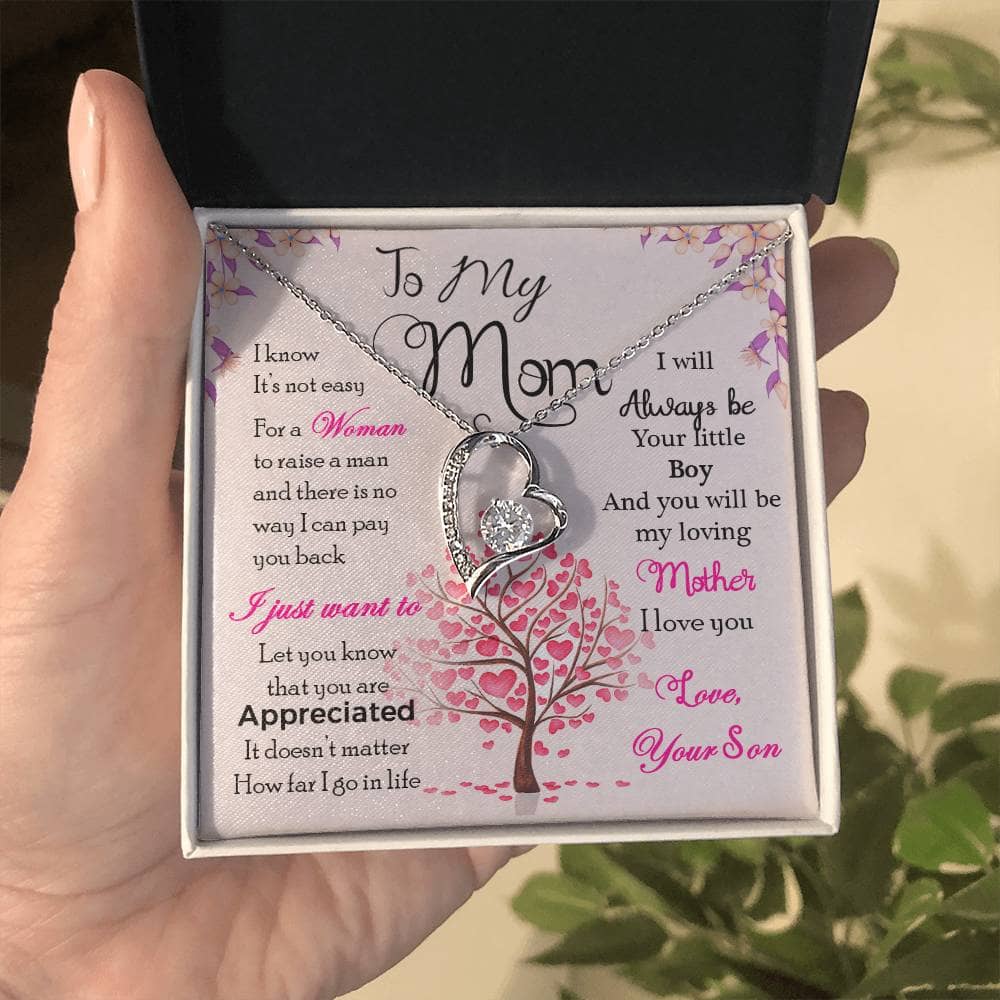 A hand holding the Enduring Love Personalized Mother Necklace in a box, symbolizing unending love and appreciation.