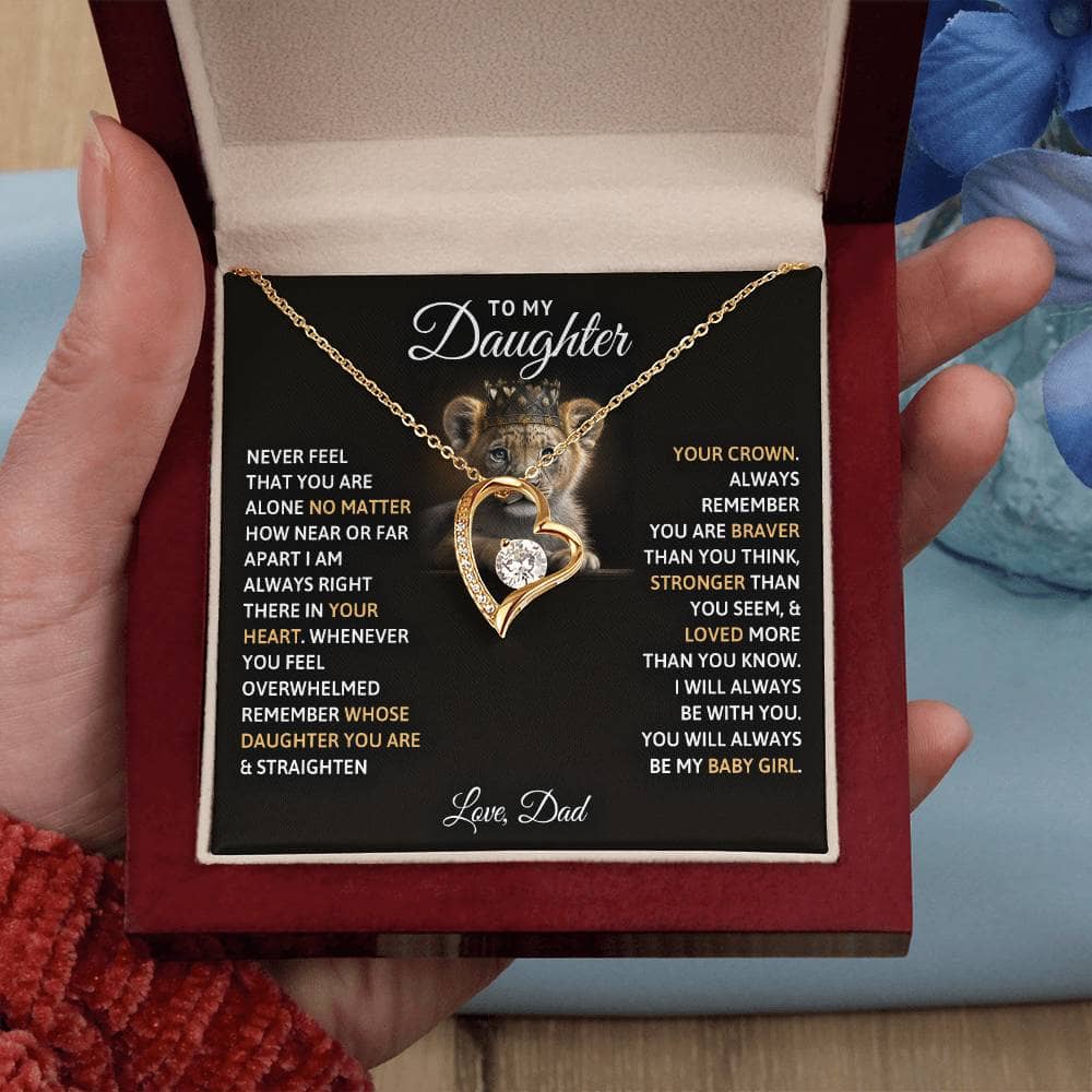 Alt text: "A hand holding a heart-shaped necklace with a picture of a mouse, symbolizing the bond between parents and daughters. The necklace is made of premium cushion-cut cubic zirconia and comes in an exquisite mahogany-style box."