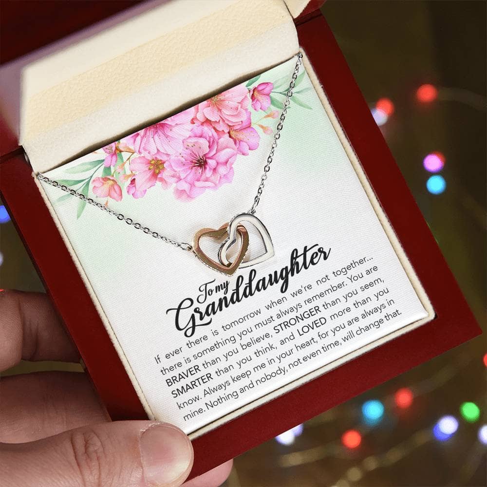 A hand holding an Interlocking Hearts Personalized Granddaughter Necklace in a box, symbolizing the profound love between grandparents and granddaughters.