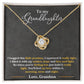 Alt text: "Love Knot Necklace: a gold necklace with a diamond pendant in a box, symbolizing the enduring bond between grandparents and granddaughters."