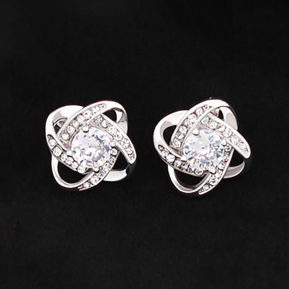 A pair of silver Love Knot Stud Earrings with a sparkling diamond-like CZ center. Perfect for adding extra sparkle to your loved one's outfit.