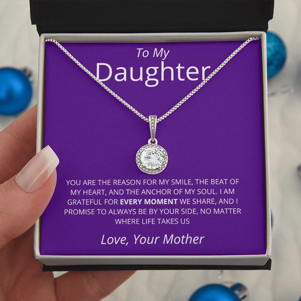 A hand holding a premium personalized daughter necklace with a heart pendant in a box.