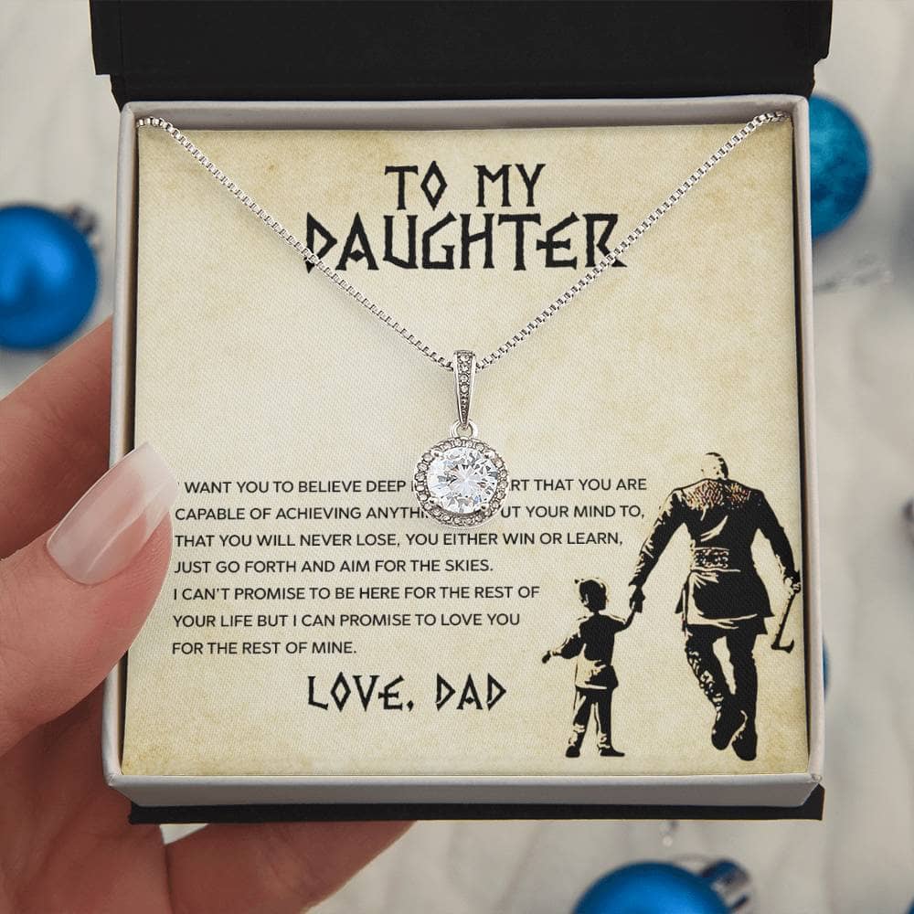 A hand holding a necklace in a box, symbolizing the unbreakable bond between a parent and daughter.