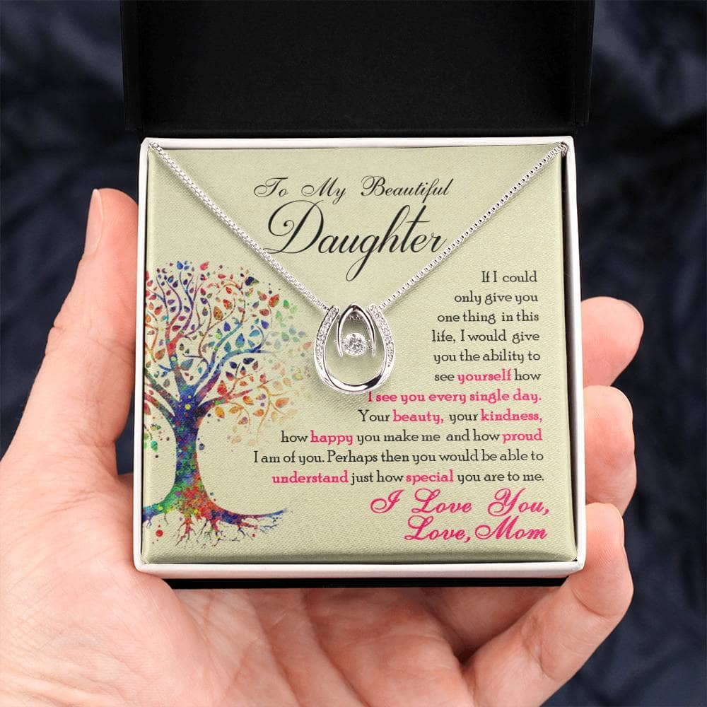 Alt text: "Hand holding elegant personalized daughter necklace with cubic zirconia heart pendant in mahogany-styled gift box"
