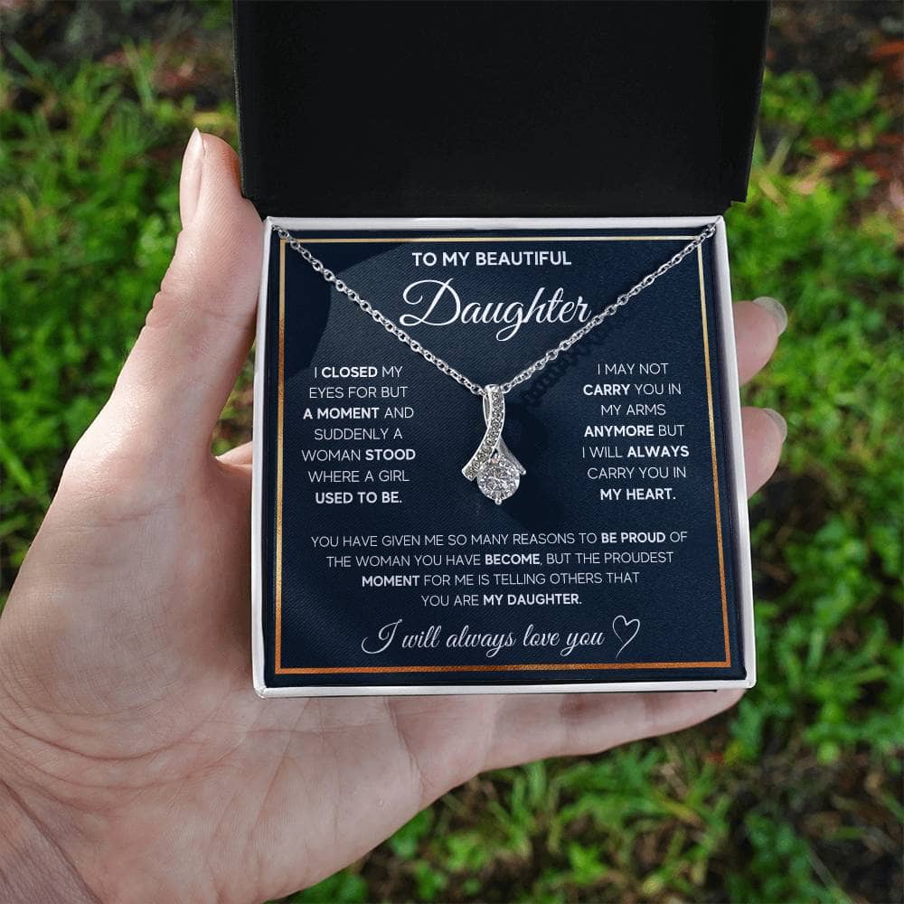 Alt text: "Hand holding Personalized Daughter Necklace with elegant heart pendant in a box"