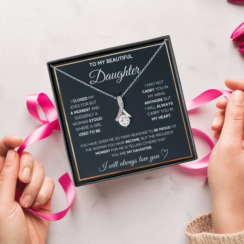 Alt text: "Hands holding a personalized daughter necklace in a box, featuring an elegant heart pendant"