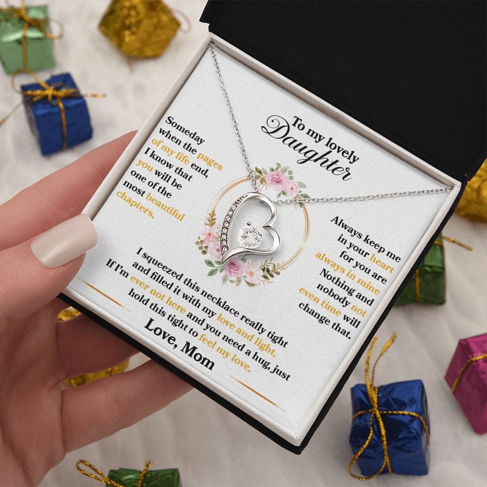 Alt text: "A hand holding a personalized daughter necklace with an elegant heart pendant, crafted with cushion-cut cubic zirconia. Packaged in a mahogany-style box with LED lighting."