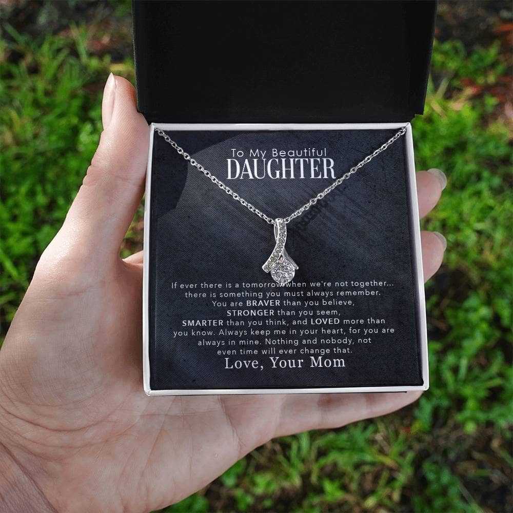 Alt text: "Hand holding 'To My Daughter' personalized necklace in box"