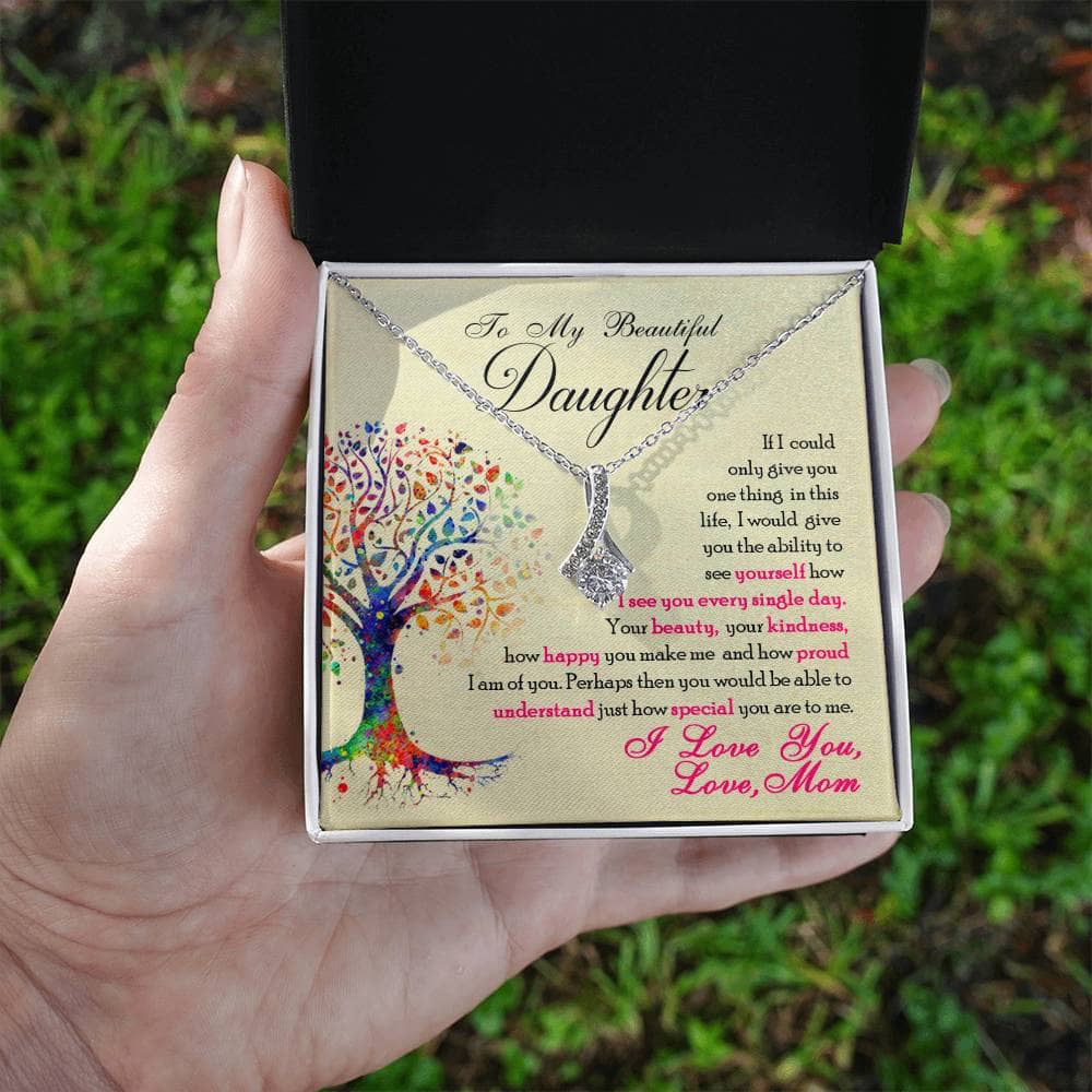 A hand holding a Personalized Daughter Necklace in a box, symbolizing the elegant and symbolic bond between a parent and daughter.