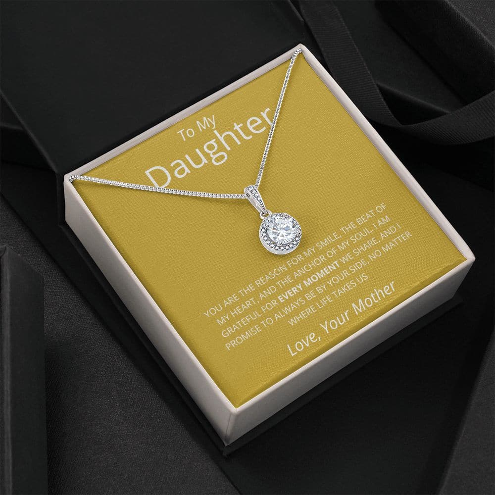Alt text: "Golden Embrace Necklace - A necklace in a box, featuring a shimmering pendant, symbolizing the unbreakable bond between mother and daughter."