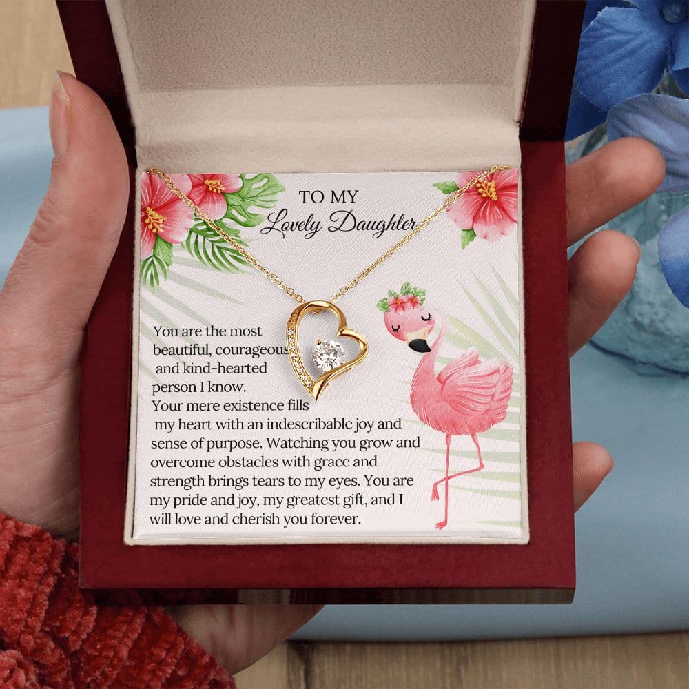 A hand holding a box with a personalized daughter necklace and a note.