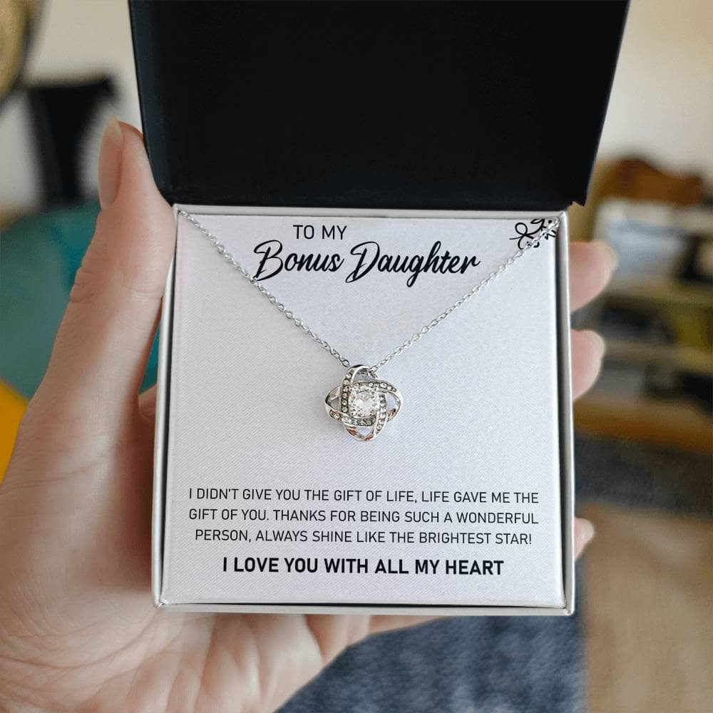 A hand holding a personalized daughter necklace in an elegant box with LED illumination.