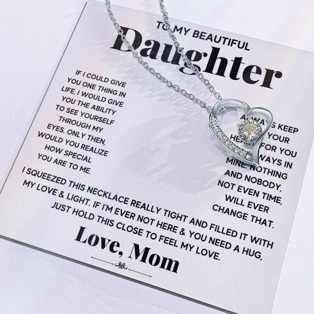Alt text: "Close-up of heart-shaped 'To My Daughter' necklace on card"